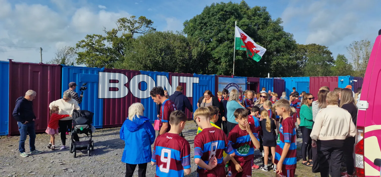 An update on a recent collaboration with the Welsh TV programme, Prosiect Pum Mil (Five Thousand Pound Project).

This TV show is focused on undertaking various community projects across local areas, all while adhering to a strict £5,000 budget.

Their most recent project was with a local football team, CPD Bontnewydd FC, who wanted to build a stand in memory of a former player, Josh Lloyd Roberts, who tragically passed away in an accident in 2023. The football club wanted to create a lasting tribute, and we worked closely with Prosiect Pum Mil to ensure the project was completed within the budget while honouring the player’s legacy.

BM Steel contributed to the project by providing the steelwork for the frame, the concrete mesh used in the groundworks, and the GRP floor sheets and nosings for the stand flooring.

The episode featuring this project is due to air on S4C in May 2025.
